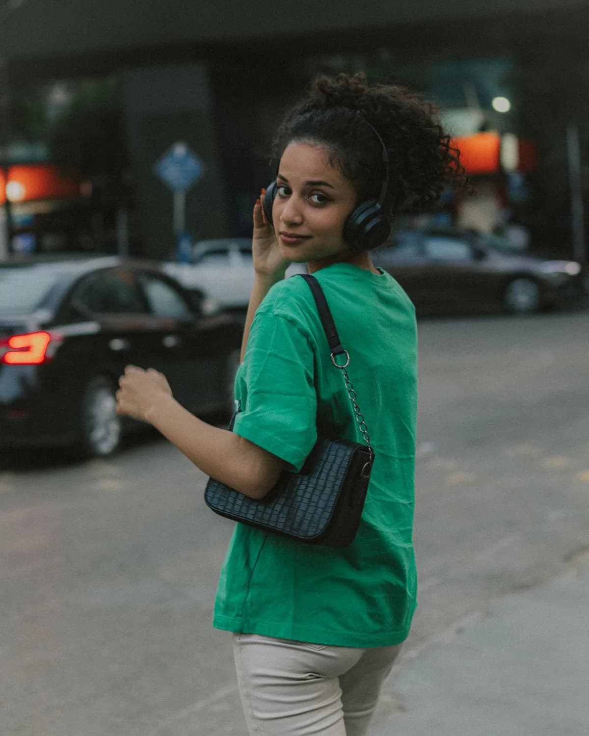 Una mujer pasea por la ciudad con auriculares