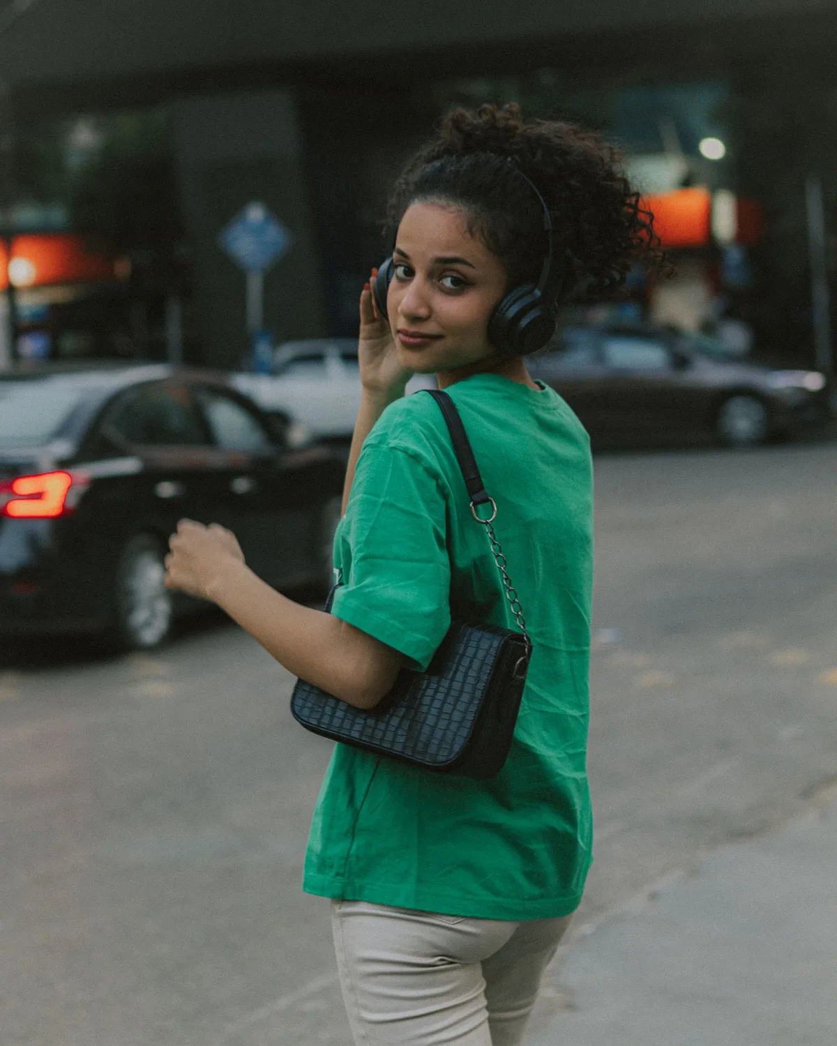 Una mujer escucha con auriculares mientras pasea por la ciudad